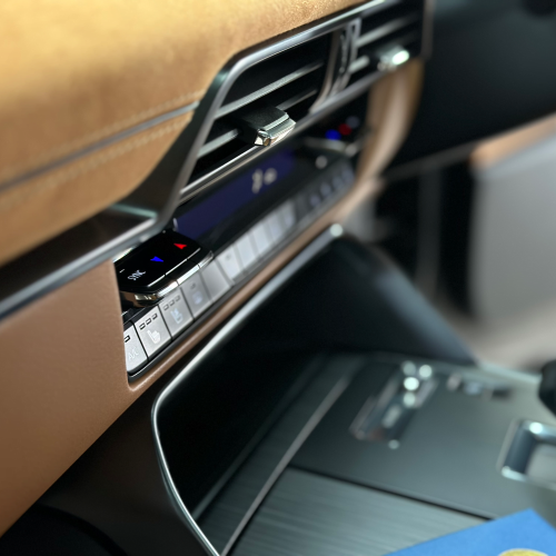 A/C close up of brown leather dashboard of a car