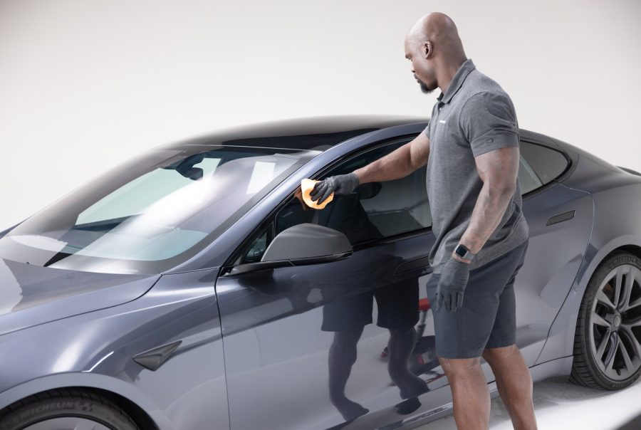 A man wiping the window of a car